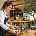 Profesional del sector hostelería y restauración gestionando una estrategia de email marketing en un restaurante con entorno digital y ambiente profesional